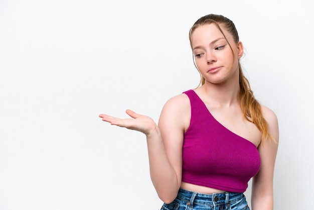 Young caucasian girl isolated on white background holding copyspace with doubts