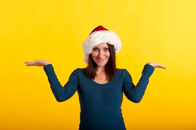 A young caucasian girl in a Santa Claus hat looking at the camera