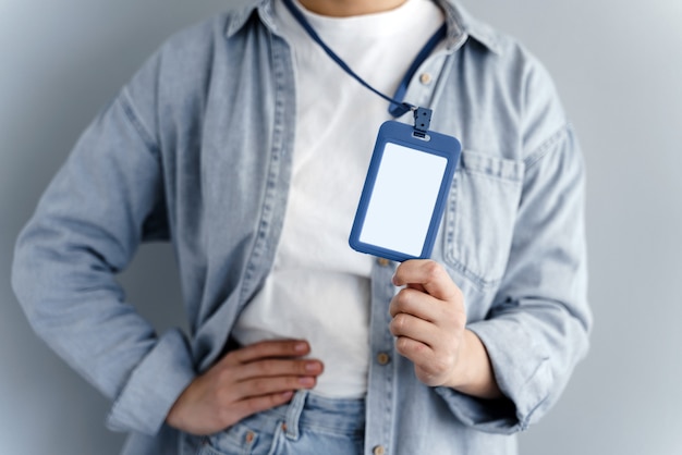 Young caucasian girl showing name tag on gray background