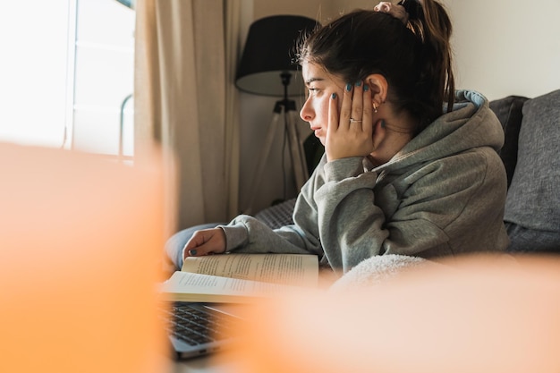 彼女の居間で勉強している若い白人の女の子