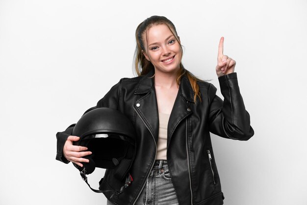 Young caucasian girl with a motorcycle helmet isolated on white background pointing up a great idea