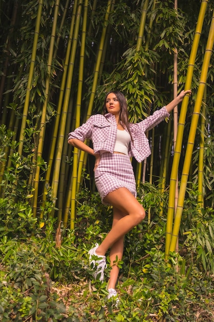 Young caucasian girl with a pink skirt in a bamboo forest Enjoying the city on summer vacation in a tropical climate lifestyle of a young girl in a trendy posing