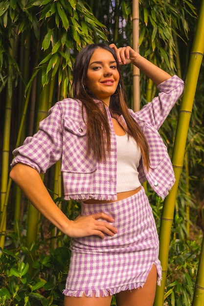 Young caucasian girl with a pink skirt in a bamboo forest Enjoying summer holidays in a tropical climate smiling looking at camera