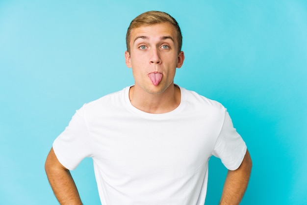 Young caucasian handsome man funny and friendly sticking out tongue.