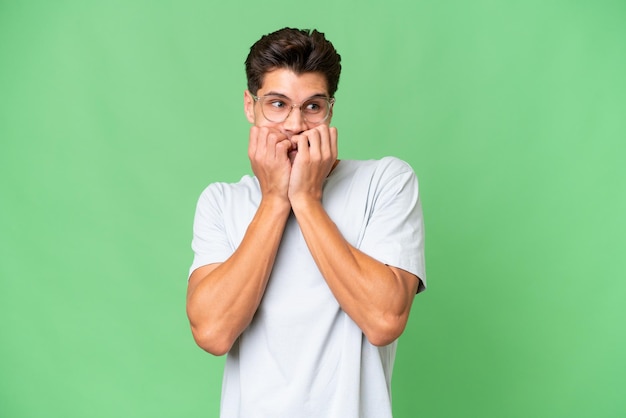 Young caucasian handsome man over isolated background nervous and scared putting hands to mouth