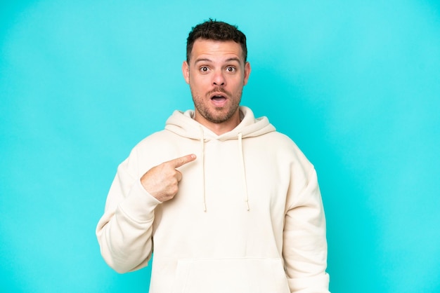 Young caucasian handsome man isolated on blue background pointing to oneself