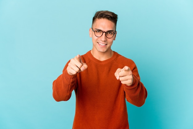 Young caucasian handsome man isolated cheerful smiles pointing to front.