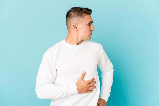 Young caucasian handsome man isolated looks aside smiling, cheerful and pleasant.