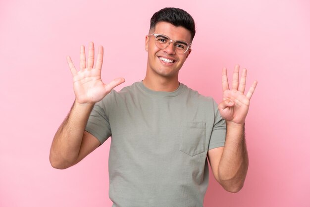 Young caucasian handsome man isolated on pink background counting nine with fingers