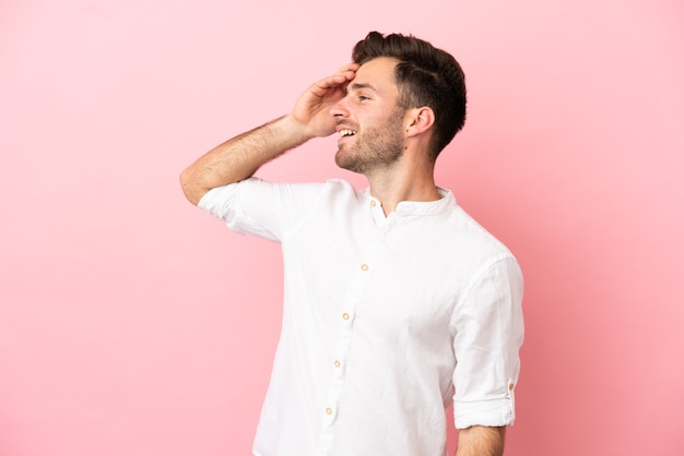 Young caucasian handsome man isolated on pink background smiling a lot