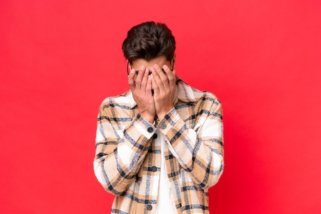 Young caucasian handsome man isolated on red background with tired and sick expression