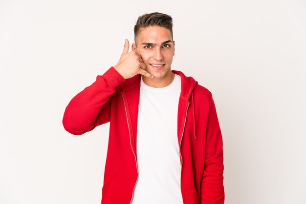 young caucasian handsome man isolated showing a mobile phone call gesture with fingers.