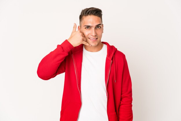 Young caucasian handsome man isolated showing a mobile phone call gesture with fingers.