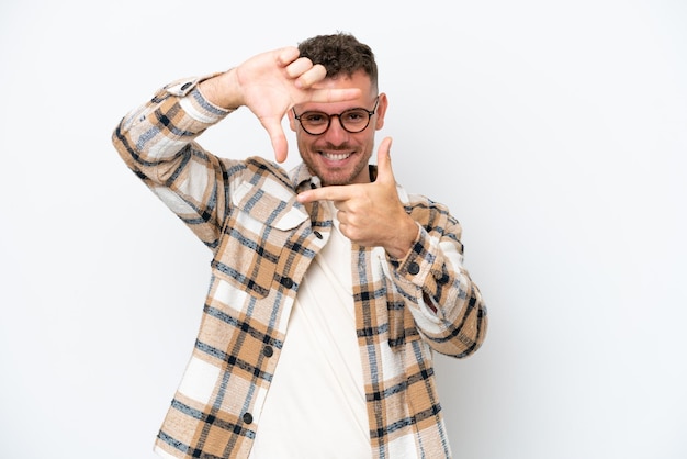 Young caucasian handsome man isolated on white background focusing face framing symbol