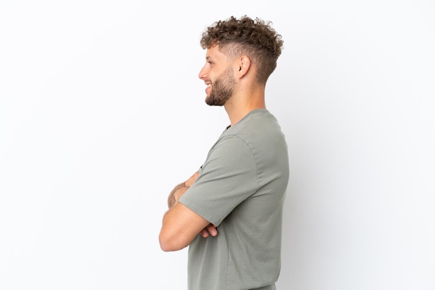 Young caucasian handsome man isolated on white background in lateral position