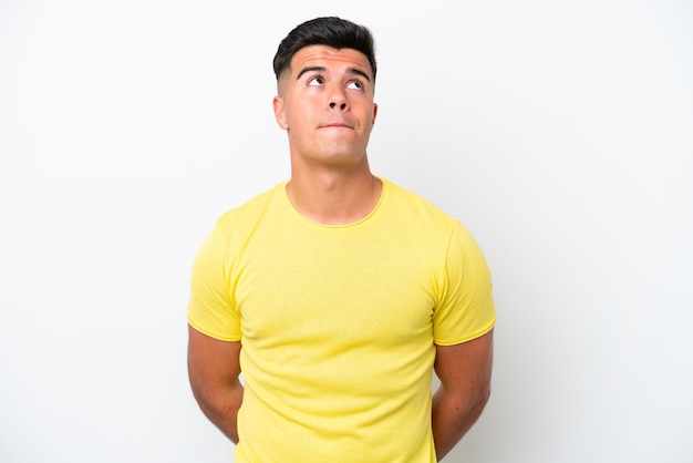 Young caucasian handsome man isolated on white background and looking up