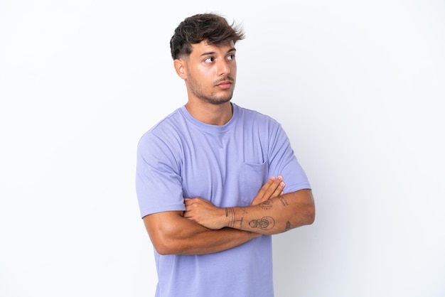 Young caucasian handsome man isolated on white background making doubts gesture while lifting the shoulders