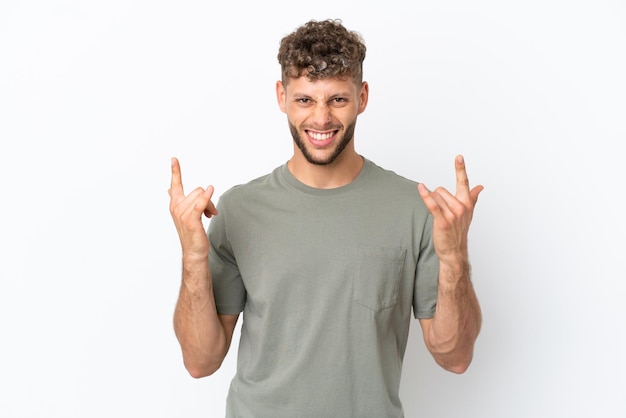 Young caucasian handsome man isolated on white background making horn gesture