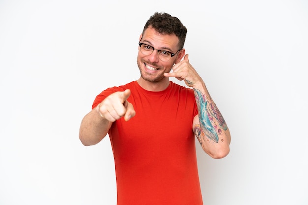 Young caucasian handsome man isolated on white background making phone gesture and pointing front