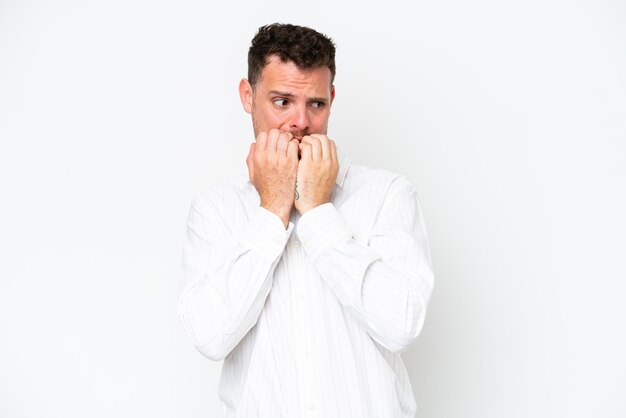 Young caucasian handsome man isolated on white background nervous and scared putting hands to mouth