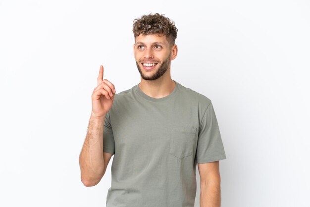 Young caucasian handsome man isolated on white background pointing up and surprised