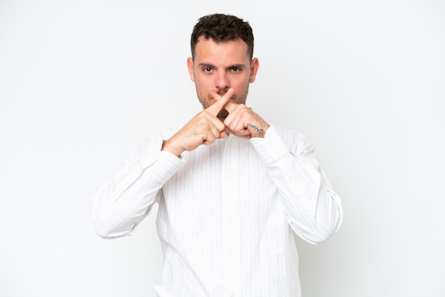 Young caucasian handsome man isolated on white background showing a sign of silence gesture