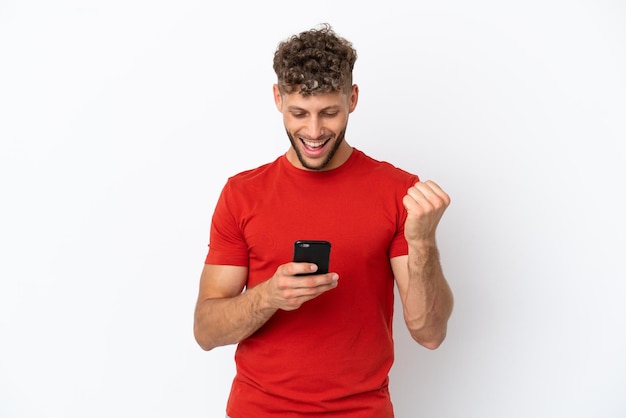 Young caucasian handsome man isolated on white background surprised and sending a message