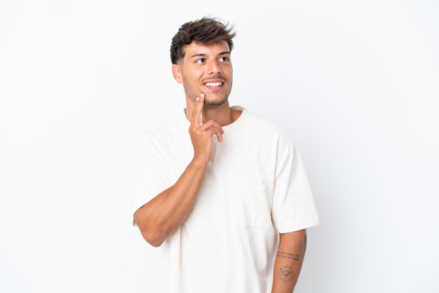 Young caucasian handsome man isolated on white background thinking an idea while looking up