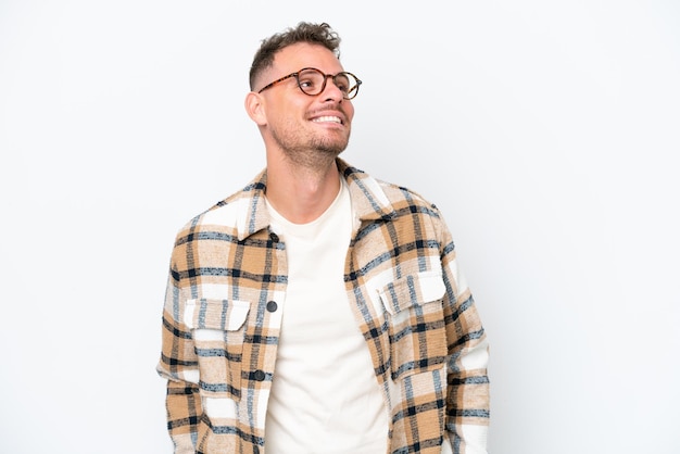 Young caucasian handsome man isolated on white background thinking an idea while looking up