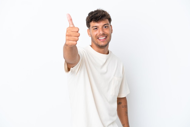 Young caucasian handsome man isolated on white background with thumbs up because something good has happened