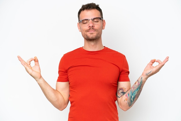 Young caucasian handsome man isolated on white background in zen pose