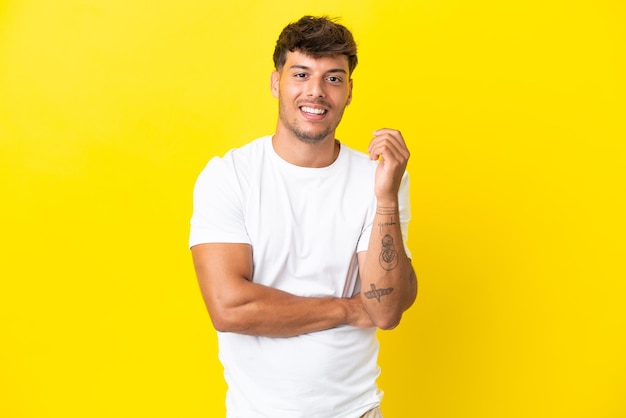 Young caucasian handsome man isolated on yellow background laughing