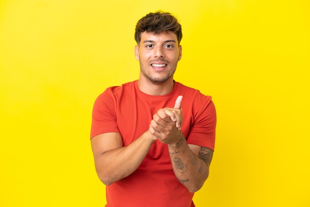 Young caucasian handsome man isolated on yellow background laughing