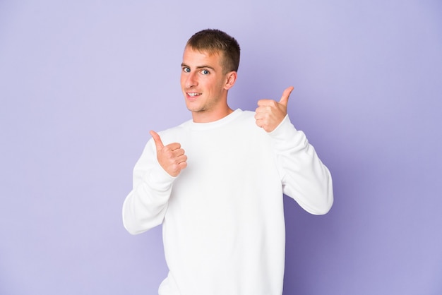 Young caucasian handsome man raising both thumbs up, smiling and confident.