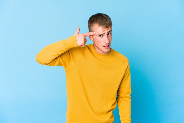 Young caucasian handsome man showing a disappointment gesture with forefinger.