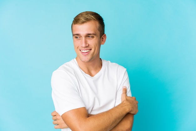 Young caucasian handsome man smiling confident with crossed arms.