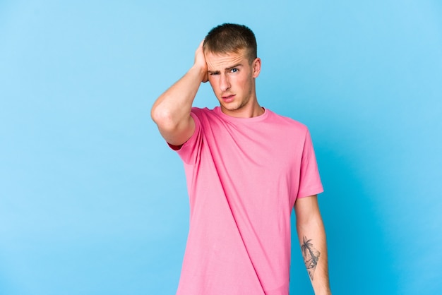 Young caucasian handsome man tired and very sleepy keeping hand on head.