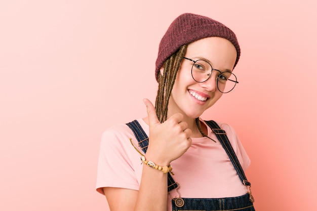 Young caucasian hipster woman smiling and raising thumb up