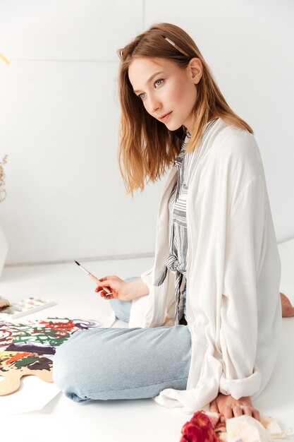 Young caucasian lady painter at workspace