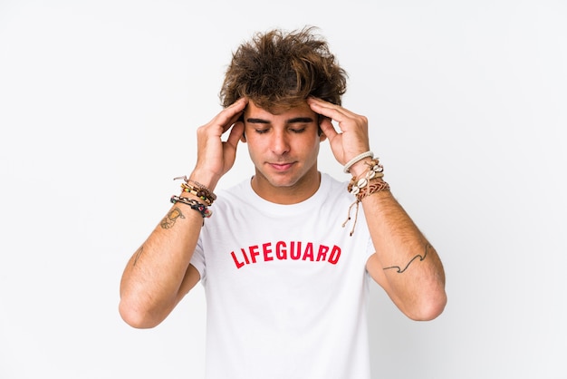 Young caucasian life guard against a white wall isolated touching temples and having headache.