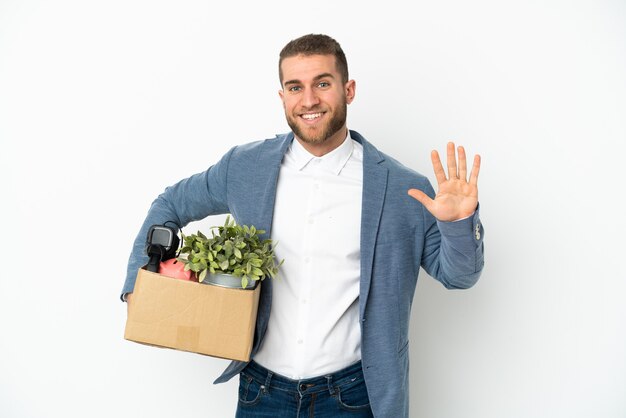 Young caucasian making a move while picking up a box full of things isolated