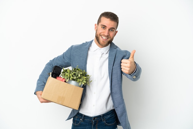 Young caucasian making a move while picking up a box full of things isolated