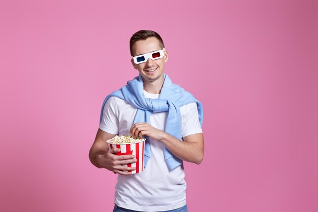 Young caucasian man in 3d glasses eating popcorn person