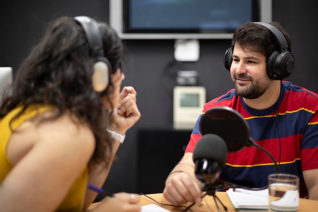 ラジオ番組の生放送中に話している若い白人男性と若い白人女性