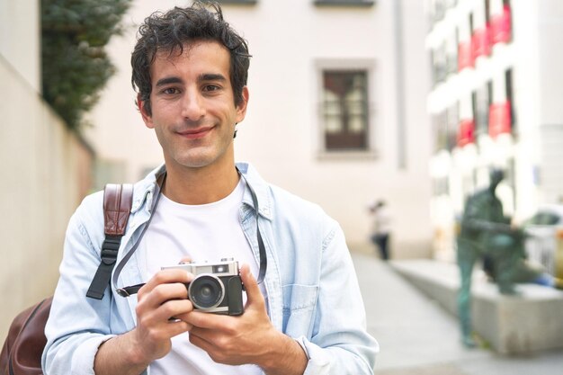 Young Caucasian man captures cherished memories with his vintage camera on a delightful vacation