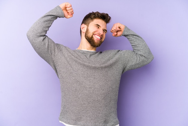 Young caucasian man celebrating a special day, jumps and raise arms with energy