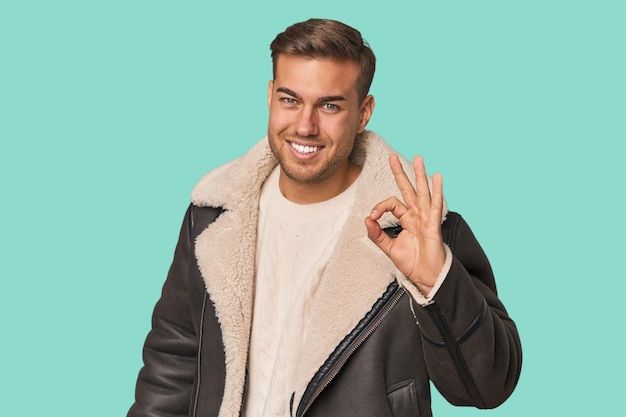 Photo young caucasian man cheerful and confident showing ok gesture