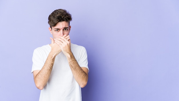 Young caucasian man covering mouth with hands looking worried.