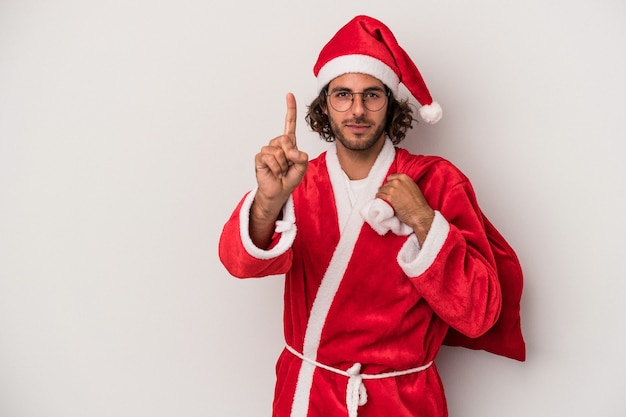 Young caucasian man disguised as santa claus isolated on gray background showing number one with finger.