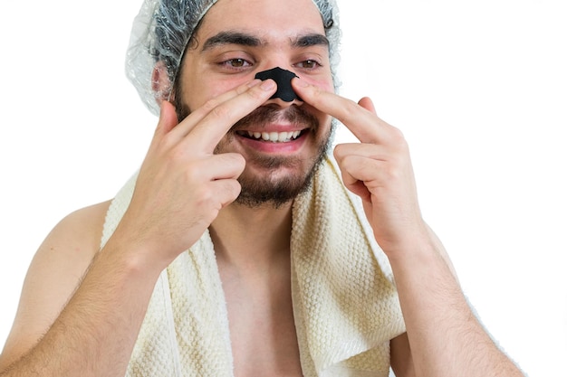 鼻の毛穴や黒い頭を取り除く洗顔をしている若い白人男性